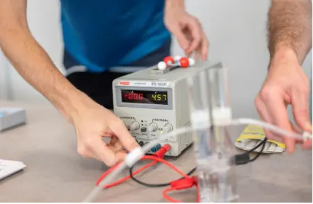 Manipulation d’un électrolyseur pédagogique avec alimentation électrique et tubes de collecte